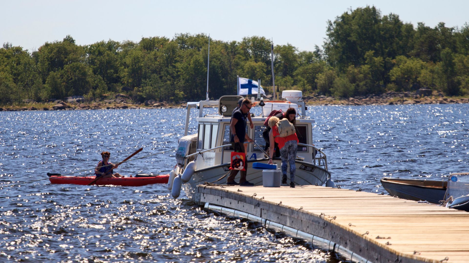 People boarding a boat at the end of the pier.